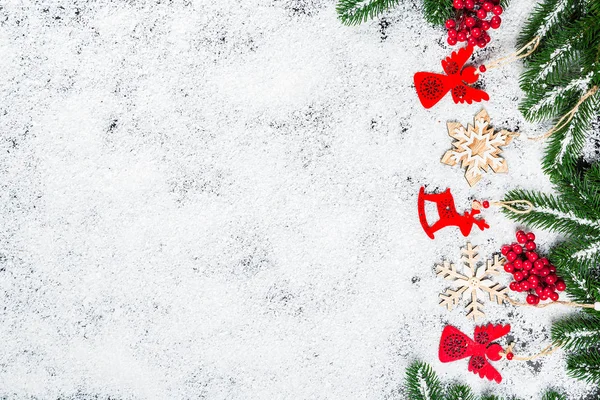 Fundo de Natal com flocos de neve, neve branca, brinquedos, doces, galhos de árvore de Natal e decoração de Ano Novo. Moldura de férias de inverno — Fotografia de Stock