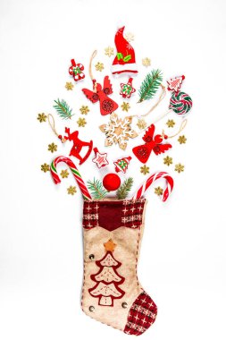 Noel arka plan hangi çorap ile hediyeler, şeker, yeni yıl süslemeleri oyuncaklar beyaz bir arka plan üzerinde dağınık. Reklam, alışveriş, indirim ve hediye için kış tatil kavramı