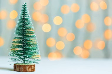 Bokeh parlayan çelenk ve beyaz tahtalar arka plan üzerine bir Noel ağacı. Mutlu Noeller, kartpostal için kış tatil için fikirler