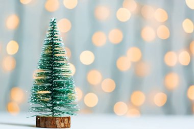 Bokeh parlayan çelenk ve beyaz tahtalar arka plan üzerine bir Noel ağacı. Mutlu Noeller, kartpostal için kış tatil için fikirler