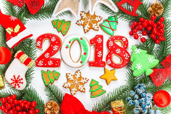 Noel çelenk süsleri, gingerbread 2018, beyaz arka plan üzerinde Xmas ağacı dalı ile birlikte. Kış ve yeni yıl tatilleri sembolü. — Stok fotoğraf