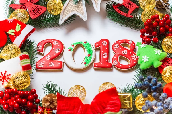 Noel çelenk süsleri, gingerbread 2018, beyaz arka plan üzerinde Xmas ağacı dalı ile birlikte. Kış ve yeni yıl tatilleri sembolü. — Stok fotoğraf