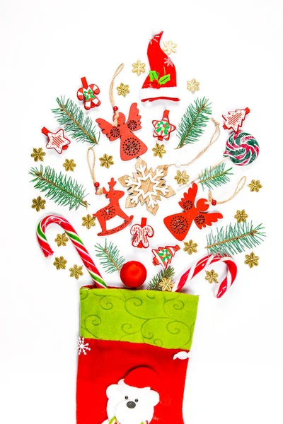 Fondo de Navidad con un calcetín desde el que los regalos dispersos, dulces, juguetes decoraciones de Año Nuevo sobre un fondo blanco. El concepto de publicidad, compras, descuentos y regalos para las vacaciones de invierno — Foto de Stock