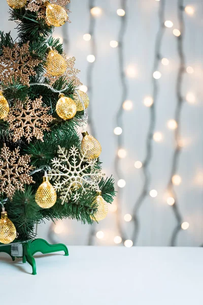 Un árbol de Navidad decorado con copos de nieve y una guirnalda en el fondo de un bokeh y pizarras blancas. Feliz Navidad, ideas para postales para vacaciones de invierno —  Fotos de Stock