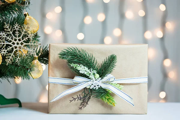 Een kerstboom ingericht sneeuwvlokken en een krans met de doos van de gift op de achtergrond van een bokeh en white boards. Vrolijke Kerstmis, ideeën voor ansichtkaarten voor wintervakantie — Stockfoto