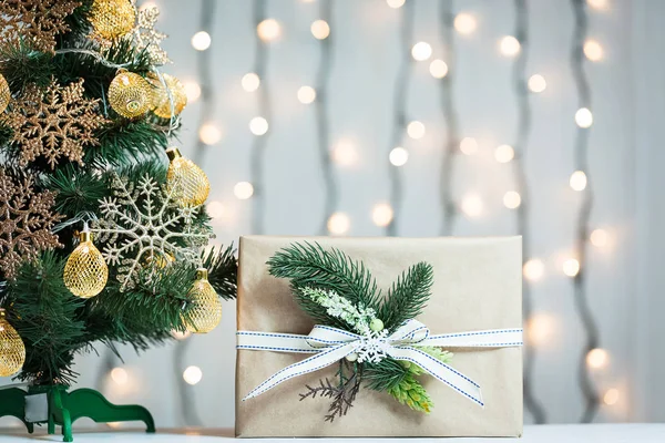 Een kerstboom ingericht sneeuwvlokken en een krans met de doos van de gift op de achtergrond van een bokeh en white boards. Vrolijke Kerstmis, ideeën voor ansichtkaarten voor wintervakantie — Stockfoto