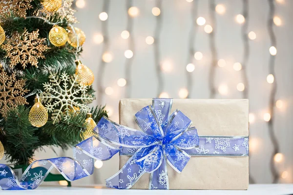 Een kerstboom ingericht sneeuwvlokken en een krans met de doos van de gift op de achtergrond van een bokeh en white boards. Vrolijke Kerstmis, ideeën voor ansichtkaarten voor wintervakantie — Stockfoto