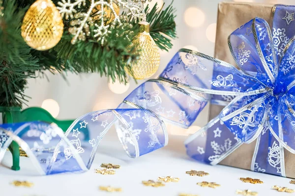 Een kerstboom ingericht sneeuwvlokken en een krans met de doos van de gift op de achtergrond van een bokeh en white boards. Vrolijke Kerstmis, ideeën voor ansichtkaarten voor wintervakantie — Stockfoto