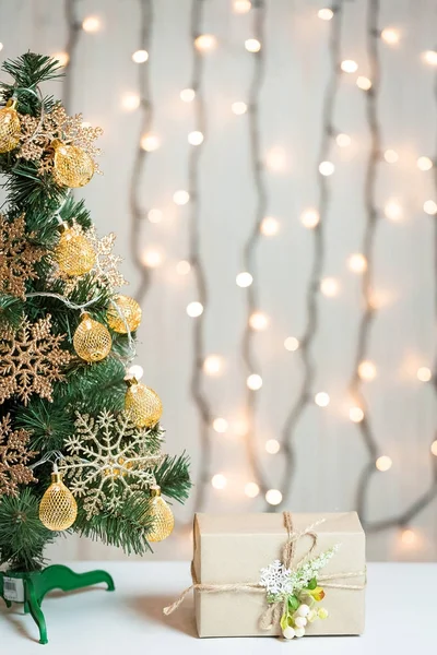 Un árbol de Navidad decorado con copos de nieve y una guirnalda con caja de regalo en el fondo de un bokeh y pizarras blancas. Feliz Navidad, ideas para postales para vacaciones de invierno —  Fotos de Stock