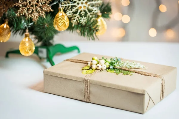 Un árbol de Navidad decorado con copos de nieve y una guirnalda con caja de regalo en el fondo de un bokeh y pizarras blancas. Feliz Navidad, ideas para postales para vacaciones de invierno —  Fotos de Stock
