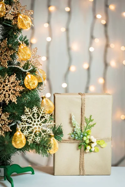 Een kerstboom ingericht sneeuwvlokken en een krans met de doos van de gift op de achtergrond van een bokeh en white boards. Vrolijke Kerstmis, ideeën voor ansichtkaarten voor wintervakantie — Stockfoto