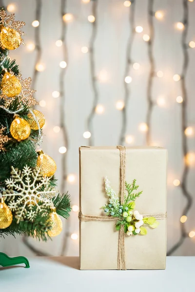 Un sapin de Noël décorait des flocons de neige et une guirlande avec une boîte cadeau sur le fond d'un bokeh et des tableaux blancs. Joyeux Noël, idées de cartes postales pour les vacances d'hiver — Photo