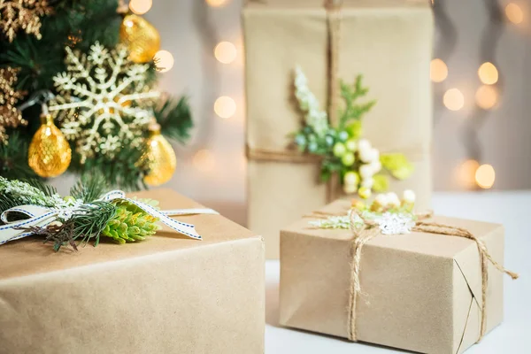 Een kerstboom ingericht sneeuwvlokken en een krans met de doos van de gift op de achtergrond van een bokeh en white boards. Vrolijke Kerstmis, ideeën voor ansichtkaarten voor wintervakantie — Stockfoto