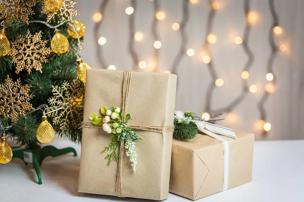 Un árbol de Navidad decorado con copos de nieve y una guirnalda con caja de regalo en el fondo de un bokeh y pizarras blancas. Feliz Navidad, ideas para postales para vacaciones de invierno — Foto de Stock