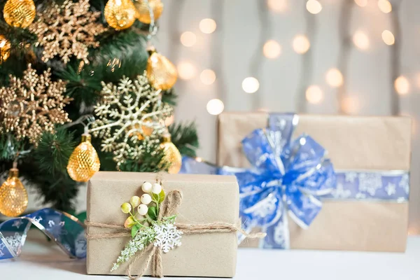 Een kerstboom ingericht sneeuwvlokken en een krans met de doos van de gift op de achtergrond van een bokeh en white boards. Vrolijke Kerstmis, ideeën voor ansichtkaarten voor wintervakantie — Stockfoto
