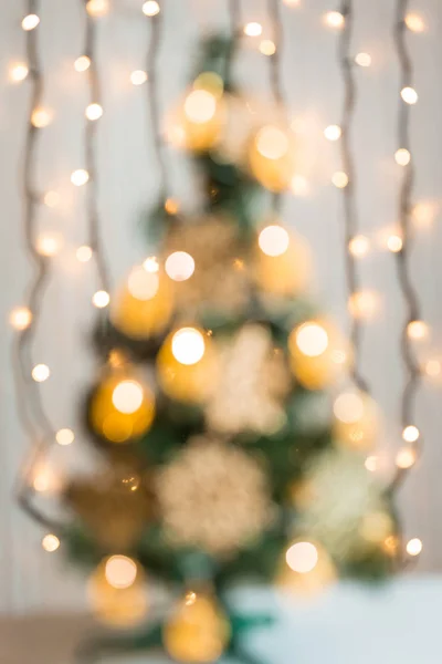 Χριστουγεννιάτικο φόντο με bokeh defocused διακοσμημένο χριστουγεννιάτικο δέντρο και λαμπερό φώτα γιρλάντα — Φωτογραφία Αρχείου