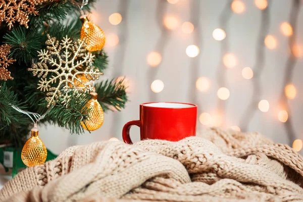 A Christmas tree decorated snowflakes and a garland, cup of coffee with knitted scarf on the background of a bokeh and white boards. Merry Christmas, ideas for postcards for winter holidays — Stock Photo, Image