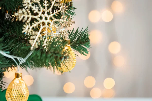 Un sapin de Noël décoré de flocons de neige et d'une guirlande sur le fond d'un bokeh et de planches blanches. Joyeux Noël, idées de cartes postales pour les vacances d'hiver — Photo