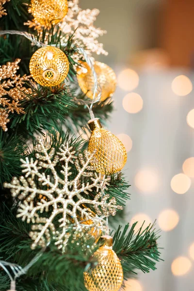 Un árbol de Navidad decorado con copos de nieve y una guirnalda en el fondo de un bokeh y pizarras blancas. Feliz Navidad, ideas para postales para vacaciones de invierno —  Fotos de Stock