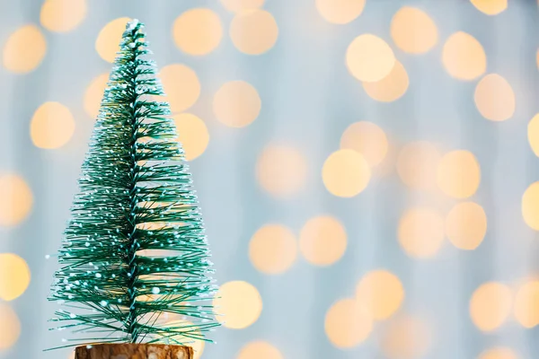 Un sapin de Noël sur le fond d'une guirlande de bokeh et de tableaux blancs. Joyeux Noël, idées de cartes postales pour les vacances d'hiver — Photo