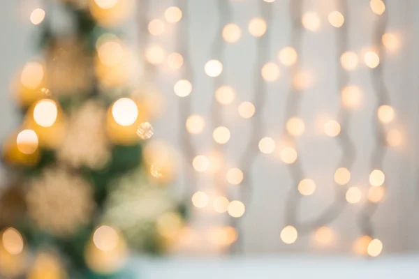 Christmas background with bokeh defocused decorated Christmas tree and glowing lights garland — Stock Photo, Image