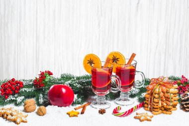 Noel cam tarçın ile masada kırmızı mulled şarap sopa, yılbaşı ağacı, kar, zencefilli, koni, şeker, Beyaz ahşap zemin üzerinde yeni yıl süslemeleri dalları. Boş alan