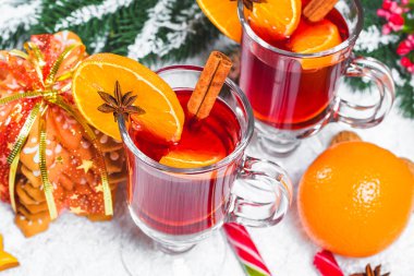 Noel cam tarçın ile masada kırmızı mulled şarap sopa, yılbaşı ağacı, kar, zencefilli, koni, şeker, Beyaz ahşap zemin üzerinde yeni yıl süslemeleri dalları. Boş alan