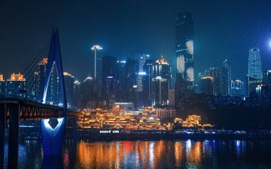 Chongqing, Çin 'in şehir gece manzarası. Nehir kenarındaki manzara. Modern mimari ve halk mimarisinin birleşimi. Şehir manzarası deniz kenarında