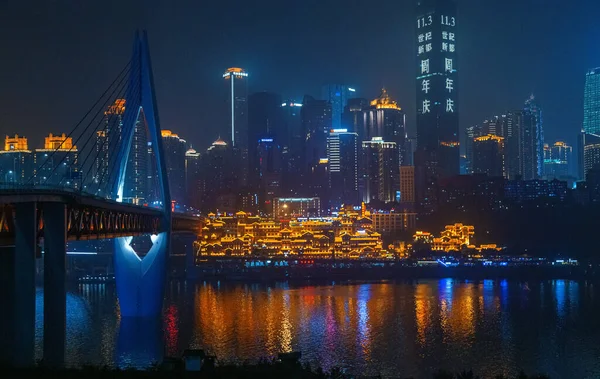 Chongqing, Çin 'in şehir gece manzarası. Nehir kenarındaki manzara. Modern mimari ve halk mimarisinin birleşimi. Şehir manzarası deniz kenarında