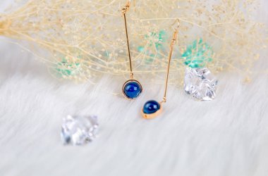 Bu bizim el yapımı küpemiz. Mavi yuvarlak boncuklar, safir taşına benzer taşlar, güzel bir doku. Solmuş bitkiler ve şeffaf buz küpleri fotoğrafçılık için iyi dekorasyonlardır. Beyaz peluş battaniye.