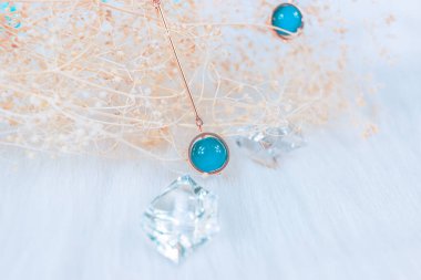 Bu bizim el yapımı küpemiz. Mavi yuvarlak boncuklar, safir taşına benzer taşlar, güzel bir doku. Solmuş bitkiler ve şeffaf buz küpleri fotoğrafçılık için iyi dekorasyonlardır. Beyaz peluş battaniye.