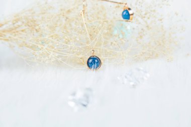 Bu bizim el yapımı küpemiz. Mavi yuvarlak boncuklar, safir taşına benzer taşlar, güzel bir doku. Solmuş bitkiler ve şeffaf buz küpleri fotoğrafçılık için iyi dekorasyonlardır. Beyaz peluş battaniye.