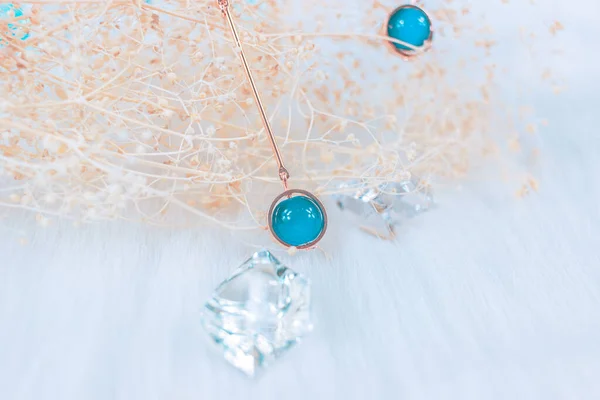 This is our own handmade earring.  Blue round beads, stones similar to sapphire, beautiful texture.  Withered plants and transparent ice cubes are good decorations for photography.  White plush blanket.