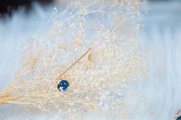 Bu bizim el yapımı küpemiz. Mavi yuvarlak boncuklar, safir taşına benzer taşlar, güzel bir doku. Solmuş bitkiler ve şeffaf buz küpleri fotoğrafçılık için iyi dekorasyonlardır. Beyaz peluş battaniye.