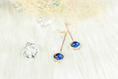 Mavi metal küpelerden yapılmış. Mavi yuvarlak boncuklar ve altın sarısı metalden yapılmış. Battaniyeler ve güzel kurumuş çiçekler süs olarak kullanılır. Solmuş bitkiler ve şeffaf buz küpleri fotoğrafçılık için iyi dekorasyonlardır..  