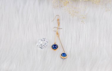 Mavi boncuk küpeler, metalden yapılmış el yapımı ürünler. Mavi yuvarlak boncuklar ve altın sarısı metalden yapılmış. Bu bizim el yapımı küpemiz. Mavi yuvarlak boncuklar, safir taşına benzer taşlar, güzel bir doku..