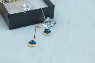 Bu bizim el yapımı küpemiz. Mavi yuvarlak boncuklar, safir taşına benzer taşlar, güzel bir doku. Solmuş bitkiler ve şeffaf buz küpleri fotoğrafçılık için iyi dekorasyonlardır. Beyaz peluş battaniye.