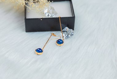 Bu bizim el yapımı küpemiz. Mavi yuvarlak boncuklar, safir taşına benzer taşlar, güzel bir doku. Solmuş bitkiler ve şeffaf buz küpleri fotoğrafçılık için iyi dekorasyonlardır. Beyaz peluş battaniye.