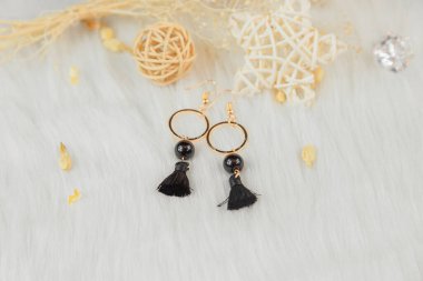 Bu küpeler bizim tarafımızdan yapılmış. Siyah püsküllü dekorasyon. Asillik ve zemin. Küpeler metalden yapılmış ve rengi de altın renginde..