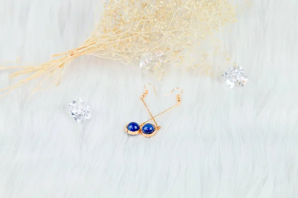 这是我们自己手工制作的耳环 蓝色的圆形珠子 类似蓝宝石的石头 质地优美 毛毯和美丽的干花被用作装饰 透明冰块道具 — 图库照片