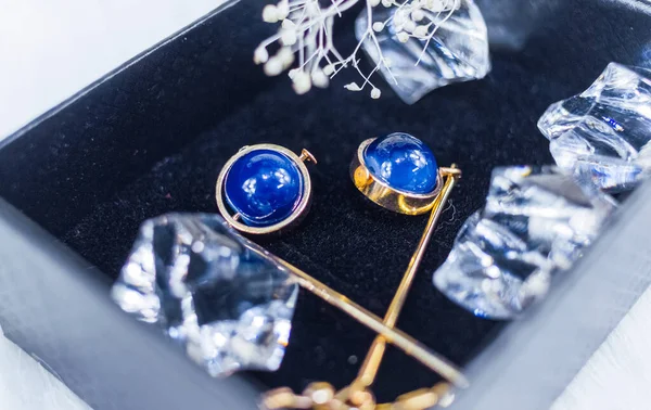 This is our own handmade earring.  Blue round beads, stones similar to sapphire, beautiful texture.  Withered plants and transparent ice cubes are good decorations for photography.  White plush blanket.