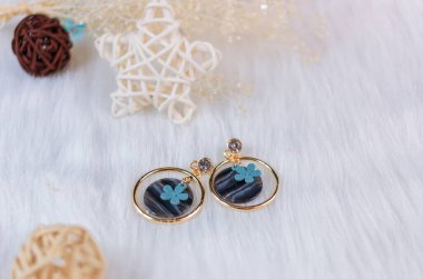 Solmuş sarı buketler ve sepak ham ürünleri. Taş süslemeli elmas küpeler.