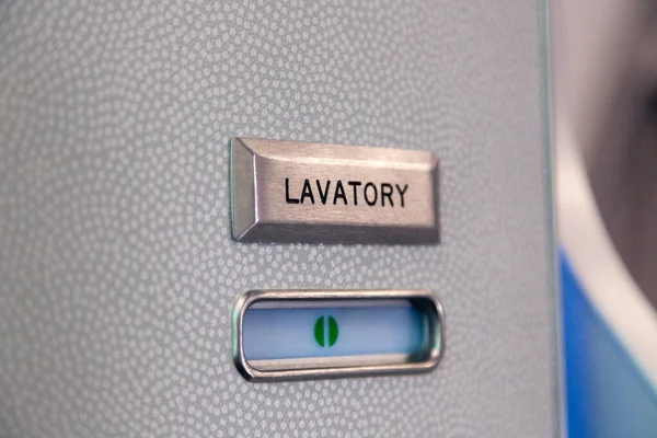 Signo verde vacante, símbolo vacante en la puerta del inodoro de un avión. Señal de lavabo de metal cepillado, signo vacío de plástico empotrado. Cuarto de baño, WC, armario a bordo del avión — Foto de Stock