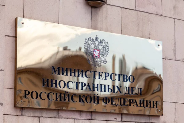 Russia Moscow 2019-06-17 Gold shiny signboard of Ministry of Foreign Affairs with Russian flag, flag of MID Russia and inscription plate on Russian. One of seven stalinism skyscrapers — Stock Photo, Image