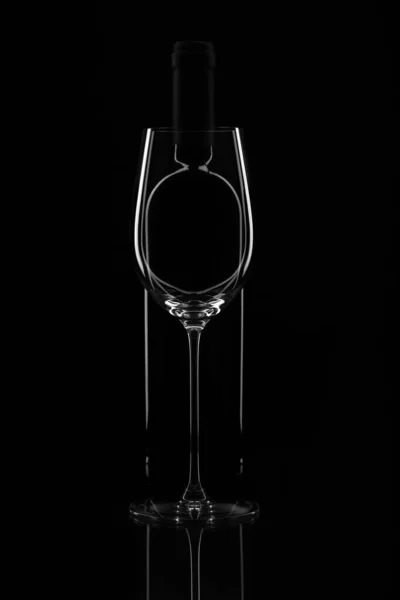 Elegant wine glass and wine bottle on black background. Bottle b — Stock Photo, Image