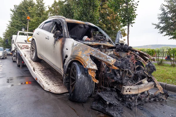 Kemerovo 2019-09-16 Branco abandonado, carro da cidade roubado Infiniti FX50S queimado é evacuado. Conceito fogo posto, crime, tentativa, ataque terrorista, emergência, queima, erro de reparação, fiação de circuito — Fotografia de Stock