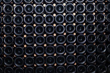 Closeup pattern from bottom of old dark dusty wine bottles in rows in cellar, basement, wine warehouse, winery. Concept vault with old rare wines, exclusive collection rare bottle. Mosaic background clipart