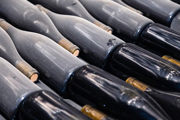 Pilhas de garrafas de vinho que colocam plana em prateleiras em adega de vinho velho o — Fotografia de Stock