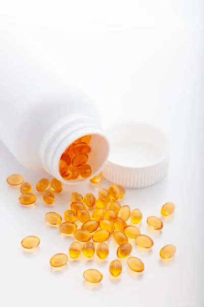 Ansicht von oben Gold Fischöl aus Tablettenflasche isoliert für eine gute Gesundheit auf weißem Hintergrund verstreut. Zusatznahrung. Omega 3. Vitamin e. Kapseln Lachsfischöl — Stockfoto