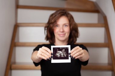 Hamile bir kadın çocuğuna bakarken kendini mutlu hissediyor. Hamile karnında bebek taşıyan hamile bir anne. Doğum öncesi bakım ve kadın hamileliği konsepti.